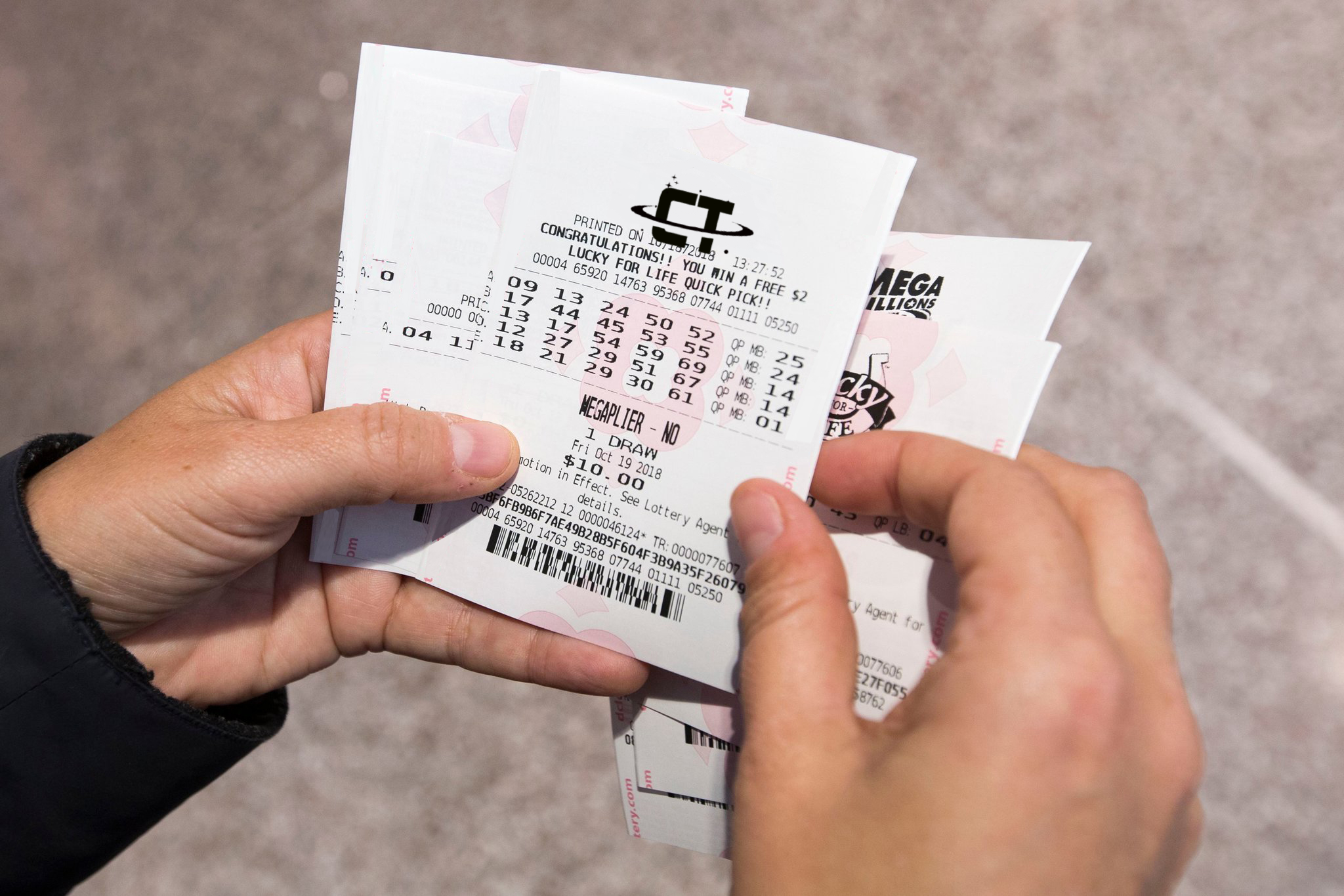 Hands holding Mega Millions lottery ticket